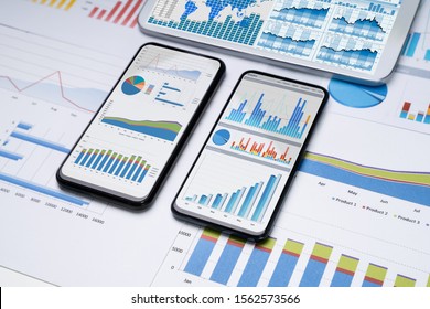 Close-up Of Financial Graphs On Screens Of Multiples Smartphones On Desk - Powered by Shutterstock