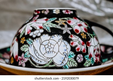 Closeup Of A Fine China Mug With Ritch Floral Motifs.