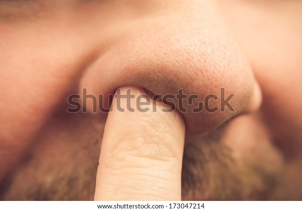 Closeup of a finger in the\
nose