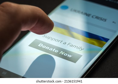 Close-up Finger Pressing Donate Button On Smartphone Screen. Donation Money Online Concept