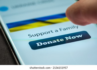 Close-up Finger Pressing Donate Button On Smartphone Screen. Donation Money Online Concept