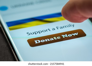 Close-up Finger Pressing Donate Button On Smartphone Screen. Donation Money Online Concept