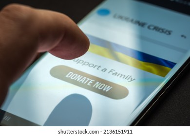 Close-up Finger Pressing Donate Icon Button On Smartphone Screen. Donation Money Online Concept