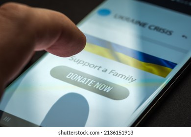 Close-up Finger Pressing Donate Icon Button On Smartphone Screen. Donation Money Online Concept