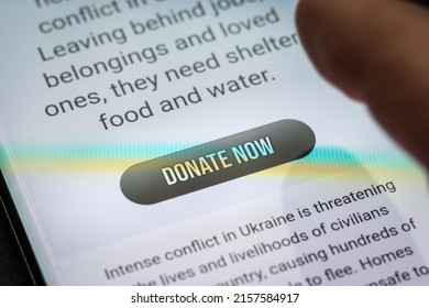 Close-up Finger Pressing Donate Icon Button On Smartphone Screen. Donation Money Online Concept