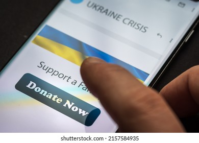 Close-up Finger Pressing Donate Icon Button On Smartphone Screen. Donation Money Online Concept