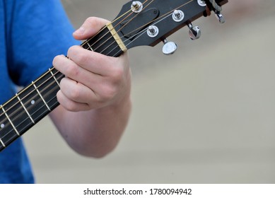 Closeup of fingers on a guitar.