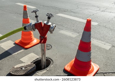 close-up Fire hydrant is connected. It is surrounded by cones for the attention of passers-by and cars