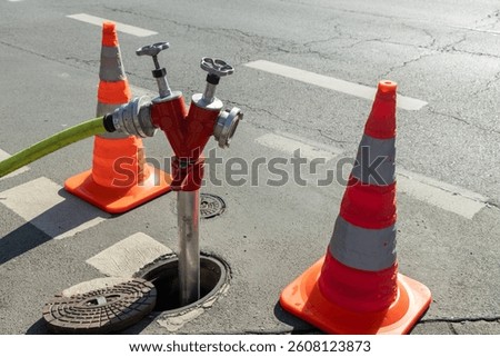 close-up Fire hydrant is connected. It is surrounded by cones for the attention of passers-by and cars
