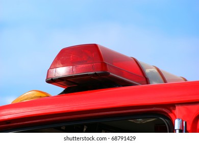 Closeup Of Fire Truck Top Lights Against Blue Sky Background.