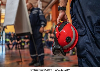 Closeup Of Firefighter Holding A Helmet And Listening To His Boss Who Is Drawing And Talking About Accident.