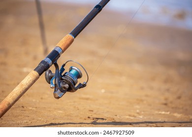 Close-up of fishing rod reels. Fishing on the shore of the lake. Spinning rods for sport fishing. - Powered by Shutterstock