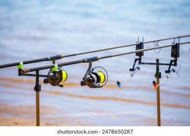 Close-up of fishing rod reels. Fishing on the shore of the lake. Spinning rods for sport fishing. - Powered by Shutterstock