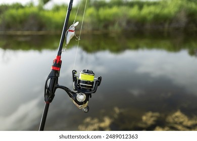 Close-up of fishing rod reels. Fishing on the shore of the lake. Spinning rods for sport fishing.