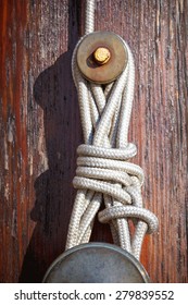 Close-up of flagpole rope mount on worn wood.