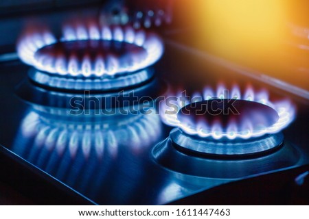 Closeup of flame gas nozzles on a stove on a dark background.