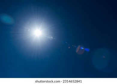 Close-up of flare spots from the sun's rays with the clear blue sky background.