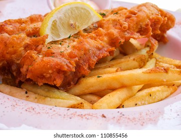 Closeup Of Flash Fried Fish And Chips On Plate With Lemon Slice