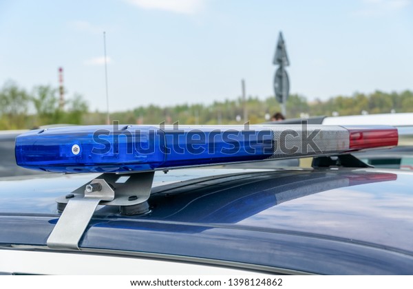 Close-up of flashing lights on a police car.\
Police flashing car roof lights outdoors. Top police patrol car\
with flasher and\
antennas