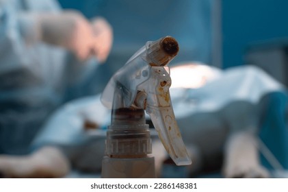Close-up. A flask with an iodine solution stands in surgery against the backdrop of an ongoing operation. In the operating room there is a spray bottle with iodine solution.