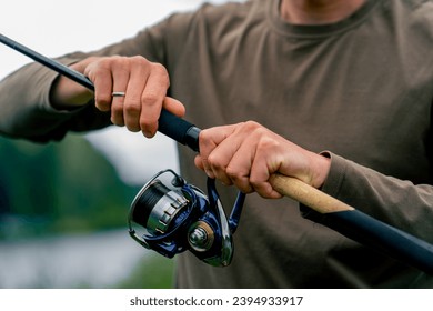 close-up Fly fisherman male hands with fishing rod spinning in hands feeder free style method - Shutterstock ID 2394933917