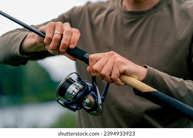 close-up Fly fisherman male hands with fishing rod spinning in hands feeder free style method - Shutterstock ID 2394933923