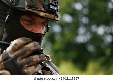 Close-up of a focused military commander giving orders through radio during an operation - Powered by Shutterstock