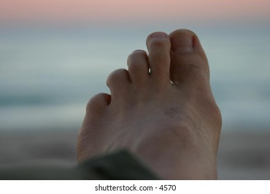 closeup of foot with beach in the background