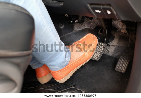 closeup foot pressing\
brake pedal of car