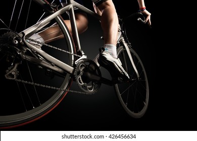 Close-up of the foot of a young man cycling. Isolated on black. - Powered by Shutterstock