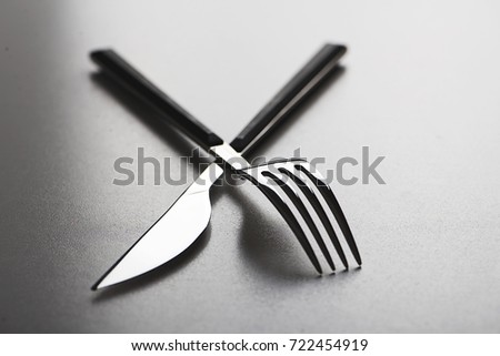 Close-up of fork and knife design on gray background. Copy space.