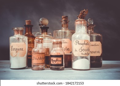 closeup of former apothecary pots with ingredients for medicine isolated over dark background. translation : terpine powder, Drosera and aubepine tincture, kola tincture, Iris essential oil, morphine