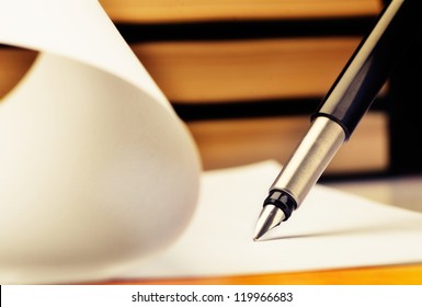 Close-up of fountain pen and book