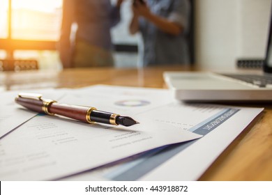 Close-up Fountain Pen Over Turnover Graph Paper It On Wood Desk In Office. 