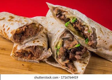 Close-up Of Four Burritos In Red Background