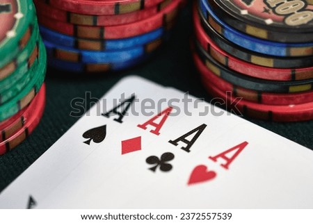 Close-up of four of a kind aces and casino chips on a casino poker table.