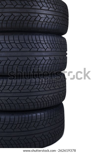 Closeup of four tires with black color\
stacked in the studio, isolated on white\
background