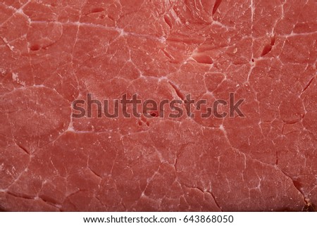 Close-up fragment of a ham meat as a background texture composition