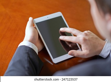 Close-up Fragment Of A Man In A Business Suit Working With The Tablet Pad Device, Behind His Shoulder Close-up Composition With A Shallow Depth Of Field