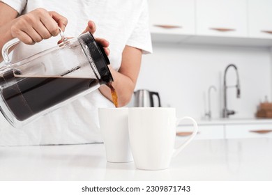 Closeup of French press and black coffee pouring into white mug. - Powered by Shutterstock