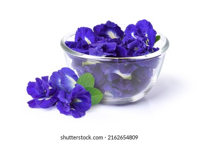 Closeup fresh butterfly pea flower or blue pea, clitoria ternatea with green leaf in wooden bowl isolated on white background.