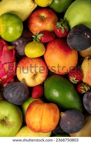 Close-up fresh colorful fruits background. Mixed fruit. Close-up. Grape, Fig, Strawberry, apple, pear, kiwi, peach. Top view