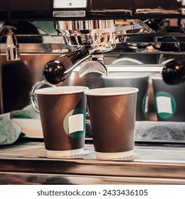 Closeup fresh espresso pouring from a coffee machine into two paper cups, espresso machine. Coffee culture and service - Powered by Shutterstock