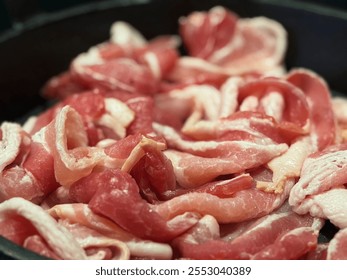 Close-up of fresh raw bacon slices in a frying pan, ready for cooking. The image highlights the bright pink and white colored marbling of the uncooked meat. Perfect for a savory breakfast side dish.  - Powered by Shutterstock