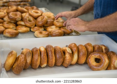 Close-up Of Freshly Baked Bagels With Seeds On Top. Hands Of Man Baking Bagels. Selective Focus.