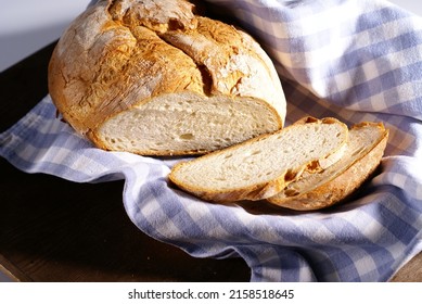 A Closeup Of A Freshly Baked Bread Loaf On A Blue Checkered Cloth