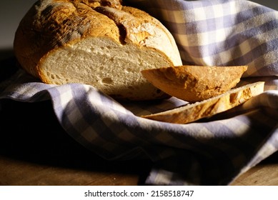 A Closeup Of A Freshly Baked Bread Loaf On A Blue Checkered Cloth