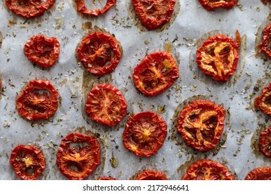 Close-up Of Freshly Dried Tomatoes With Herbs On Parchment Paper Straight From The Oven