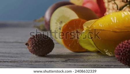 Close-up freshly picked tropical ripe fruits - carambola, litchi and passion fruit on a wooden background. Vegetarian healthy concept. Panoramic motion, 4K video, 3840, 2160p.