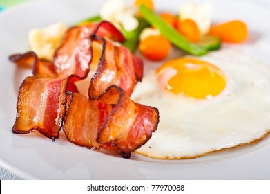 Close-up Of Fried Egg With Bacon And Vegetables.